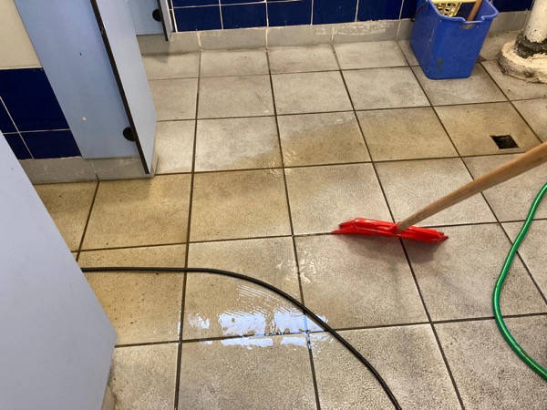 DrainFix HK 完成廁所通渠後用紅色刮水器將濕地板水推走 — 離場前整潔現場
