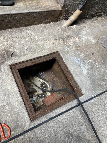 DrainFix HK 師傅人手操作刨渠工具，攪碎方井內堵塞物
