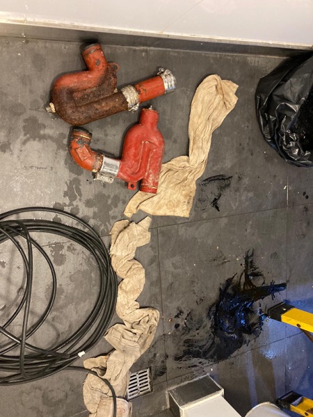 DrainFix HK 同一單拆出嘅多段紅鑄鐵渠管擺在客戶廚房地下，連 stainless coupling