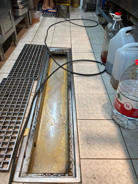 DrainFix HK 食肆長條形隔油池清渠中，高壓水管伸入沖洗 — 真實營業時段工作