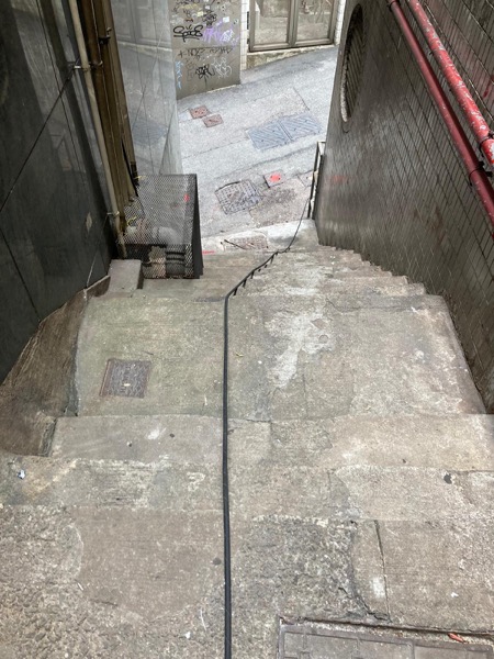 DrainFix HK 食肆後巷石階旁排水管系統，師傅將通渠線由樓梯下方引導至地下渠口